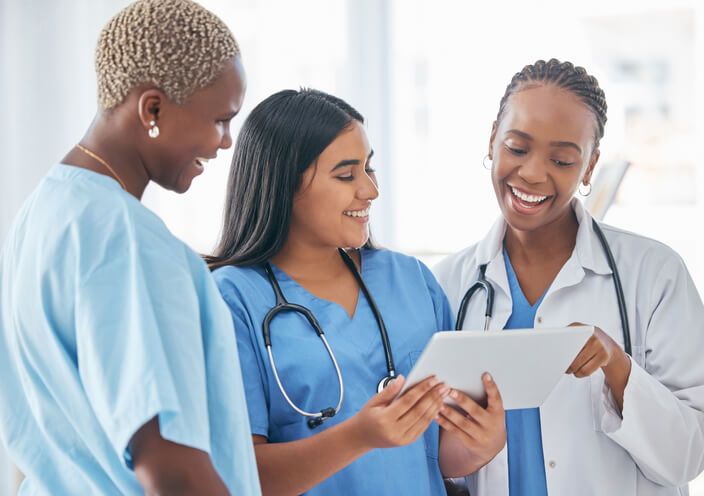 A team of medical office specialists working together on a tablet