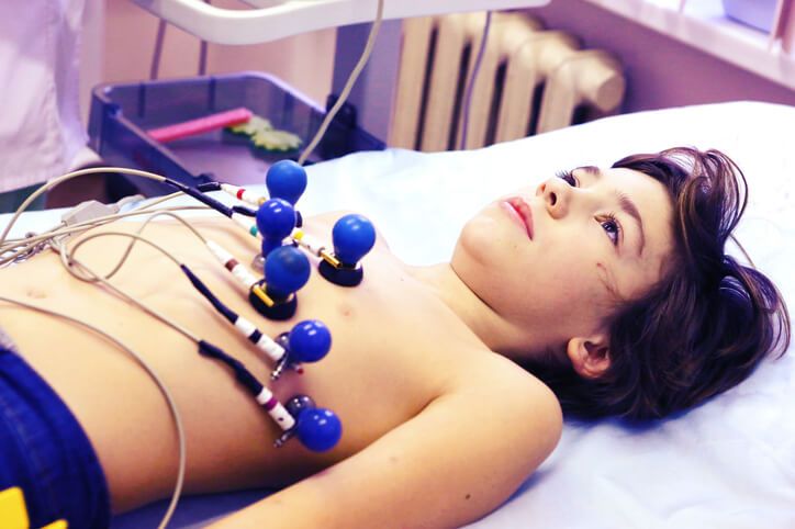 An EKG technician operating an ECG machine after completing their medical office specialist diploma