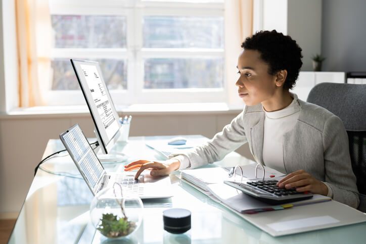 A female medical office specialist in an office after completing her medical office specialist training