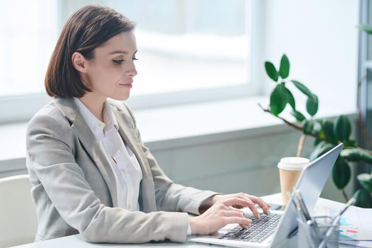 A female medical office specialist working on a computer after completing her medical office specialist training